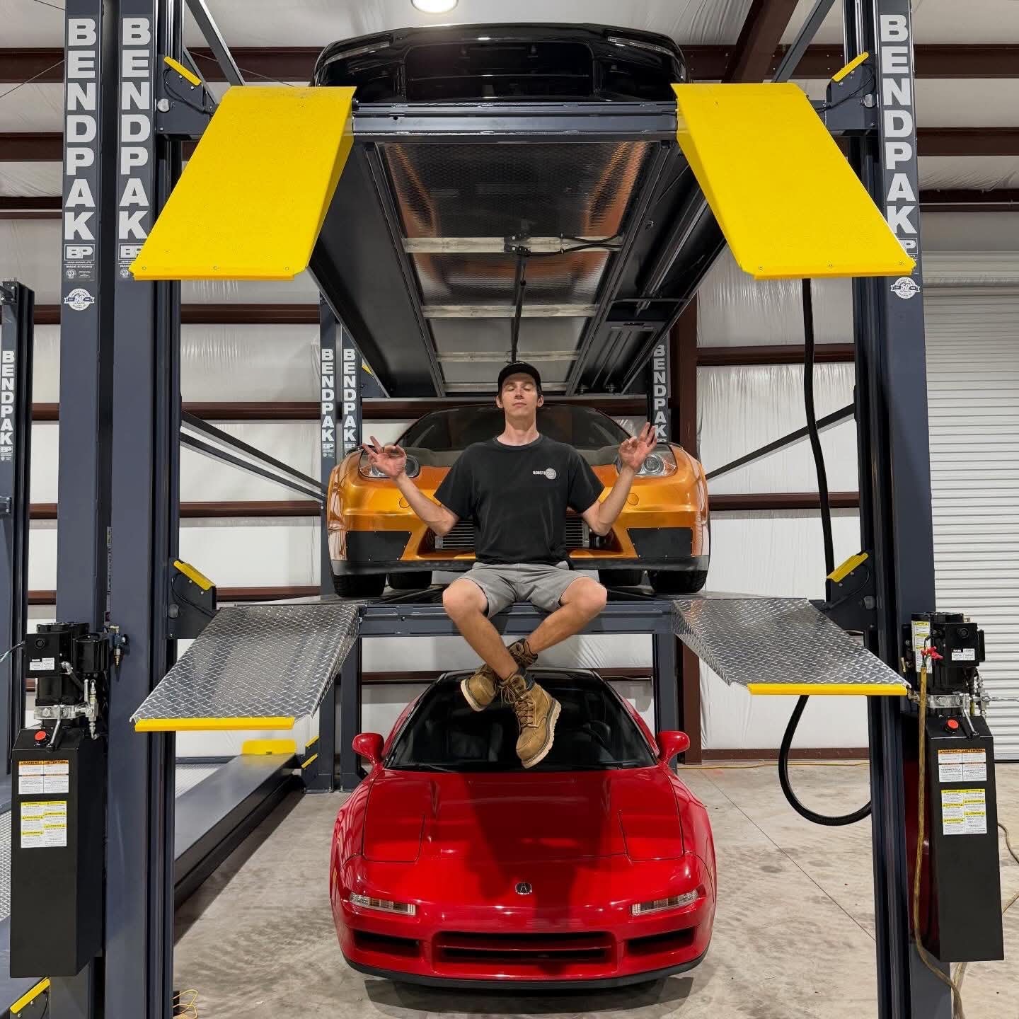 Two cars stacked on a two-tier hydraulic storage lift